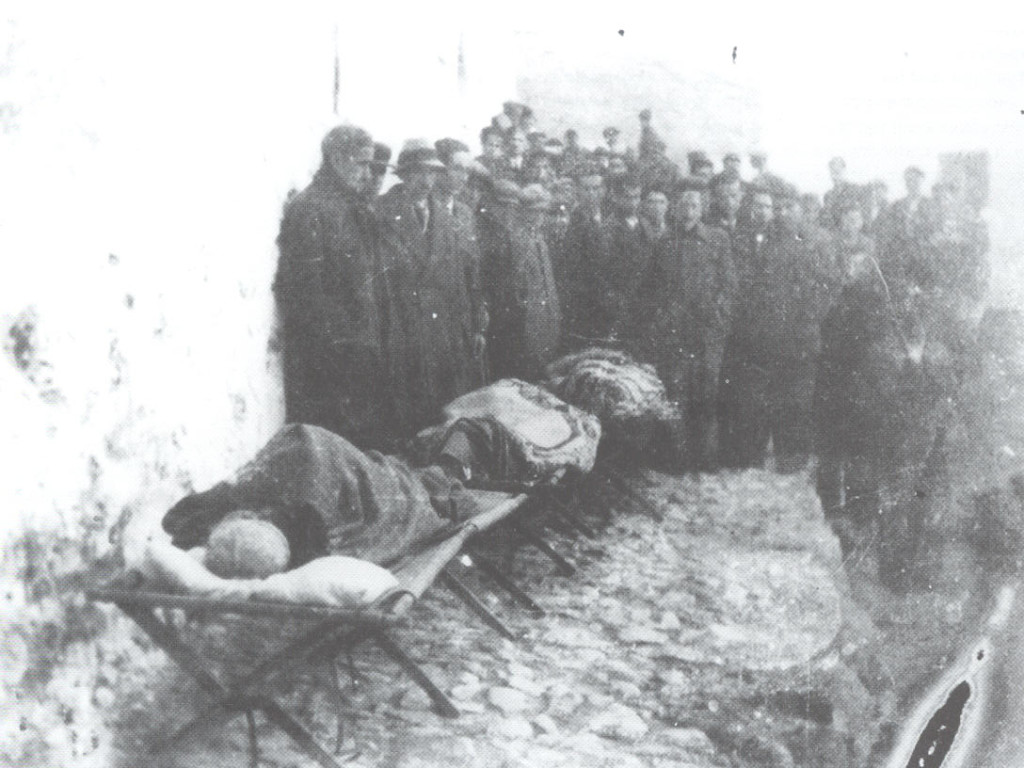 Οι σκελετωμένοι εξόριστοι πάνω σε ράντζα στο δρόμο του χωριού. Ανάμεσά τους ο Μανώλης Περλορέντζος