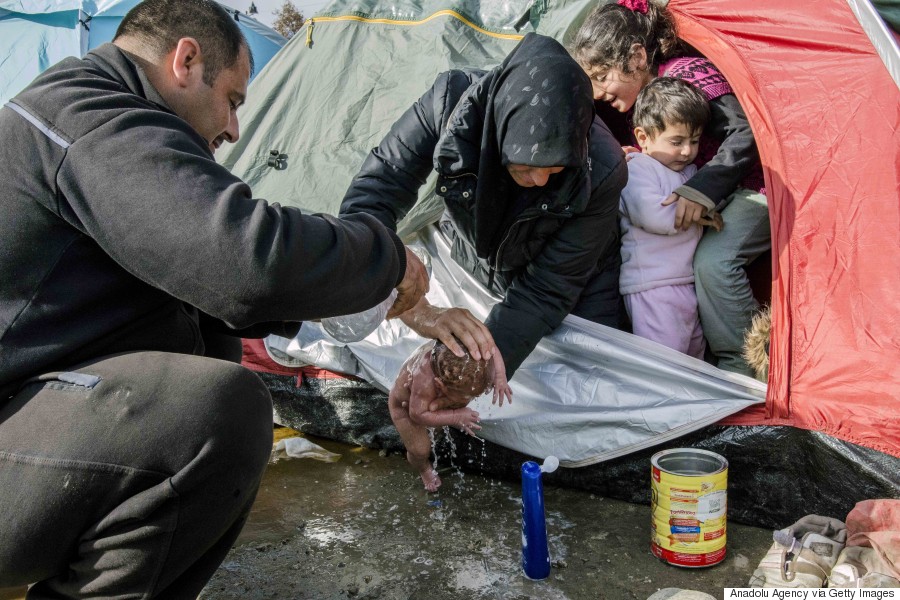 IDOMENI, GREECE - MARCH 6: Refugees wash a new born baby as they stay in tents that they set up in the Idomeni town in Greece, near the Macedonian border on March 6, 2016.  (Photo by Iker Pastor/Anadolu Agency/Getty Images)