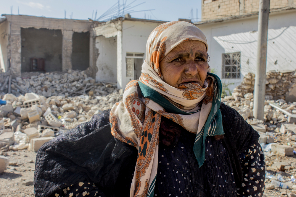 Συρία: Η Αμνέχ έφυγε με την οικογένειά της από την συνοικία Αλ Μισλάμπ ανατολικά της Ράκα, πριν από οκτώ μήνες. Επέστρεψε μετά από καιρό για να ελέγξει το σπίτι της. Τα περισσότερα σπίτια στην περιοχή είχαν καταστραφεί. Η Αμνέχ στέκεται μπροστά από τα ερείπια του σπιτιού της εγγονής της. «Θα προσπαθήσουμε να το ξαναφτιάξουμε, αλλά δεν υπάρχουν ακόμη υπηρεσίες στην περιοχή» λέει. (Νοέμβριος 2017) πηγη: Diala Ghassan/MSF
