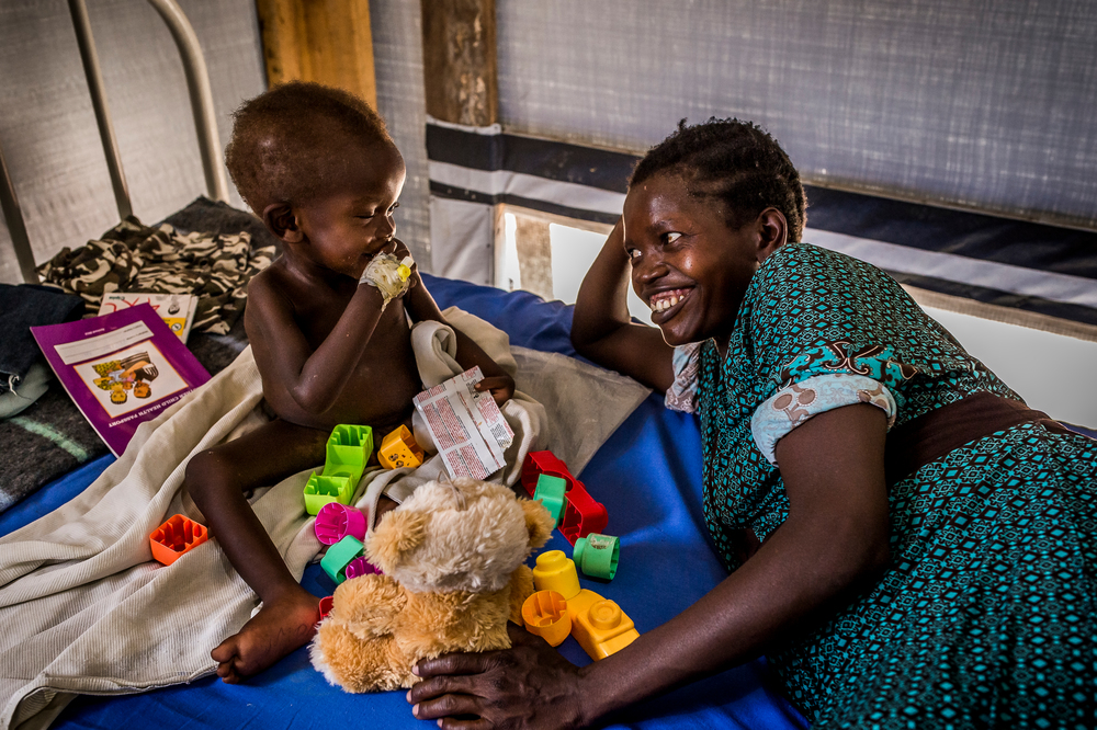 Ουγκάντα: Στο τμήμα ασθενών του Μπιντιμπίντι στη μονάδα των Γιατρών Χωρίς Σύνορα για την καταπολέμηση του υποσιτισμού ένα παιδί απολαμβάνει μερικές στιγμές χαράς, παίζοντας μαζί με τη μητέρα του. (Απρίλιος 2017). πηγη: Frederic NOY/COSMOS